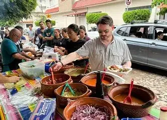 Visitantes disfrutando auténticos tacos mexicanos en un tradicional puesto local durante una experiencia gastronómica en Puerto Vallarta.